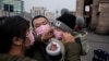 Люди в защитных масках на железнодорожном вокзале в Пекине. 27 января 2020 года.