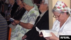 Верующие в церкви с библией в руках. Иллюстративное фото.