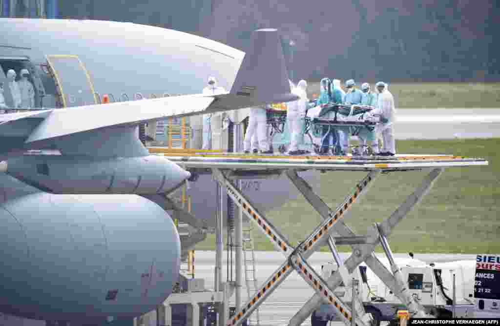 Medical staff embark patients infected with the coronavirus onto a French Air Force jet on April 3 at the Findel airport in Luxembourg.