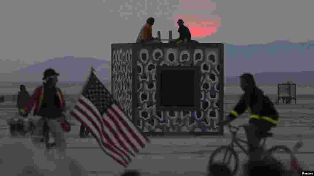 Festival-goers gaze at the rising sun during this year&#39;s Burning Man arts and music festival.