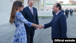 Рукопожатие президента Франции Франсуа Олланда с первой леди Азербайджана во время встречи в аэропорту Баку 
