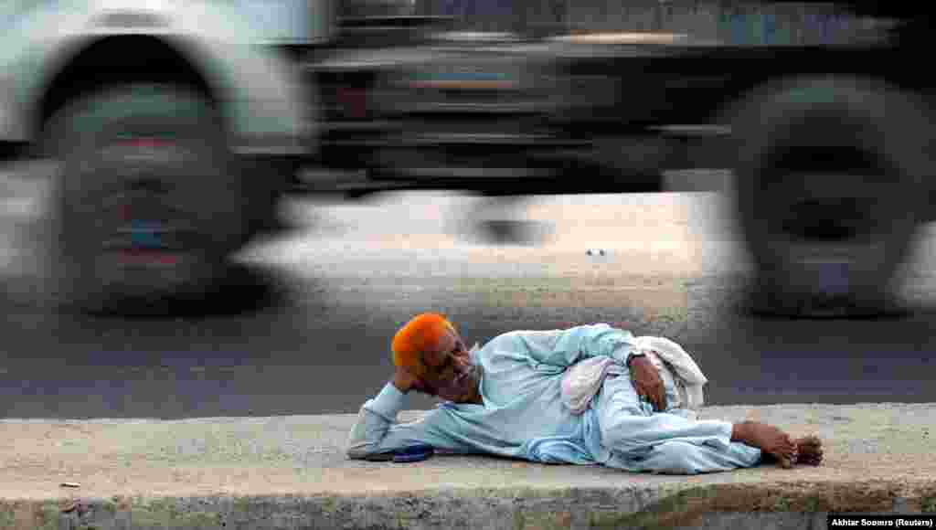 A man with henna-dyed hair rests on a road near the port area in Karachi, Pakistan. (Reuters/Akhtar Soomro)