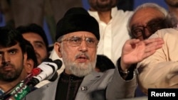 Pakistani opposition cleric Mohammad Tahir ul-Qadri addresses his supporters outside the parliament building in Islamabad on August 21.