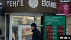 Молодой человек проходит мимо пункта обмена валют. Алматы, 11 февраля 2014 года.