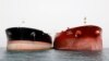 A picture taken on March 12, 2017, shows an Iranian tanker and a South Korean (R) tanker docking at the platform of the oil facility in the Khark Island, on the shore of the Gulf.