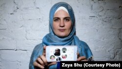 Mumine Saliyeva holding a picture of her imprisoned husband and their four children.