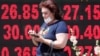 Жінка проходить повз табло з курсами валют, Київ, 2 липня 2020 року