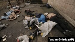 Тела убитых мужчин возле одного из зданий в Буче, у некоторых из них связаны руки. 3 апреля 2022 года. Фото: AP