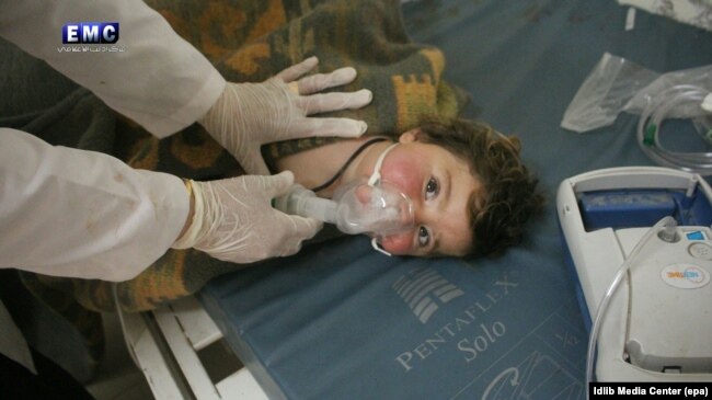 Медики оказывают помощь ребенку, пострадавшему в ходе предположительной химической атаки в сирийской провинции Идлиб