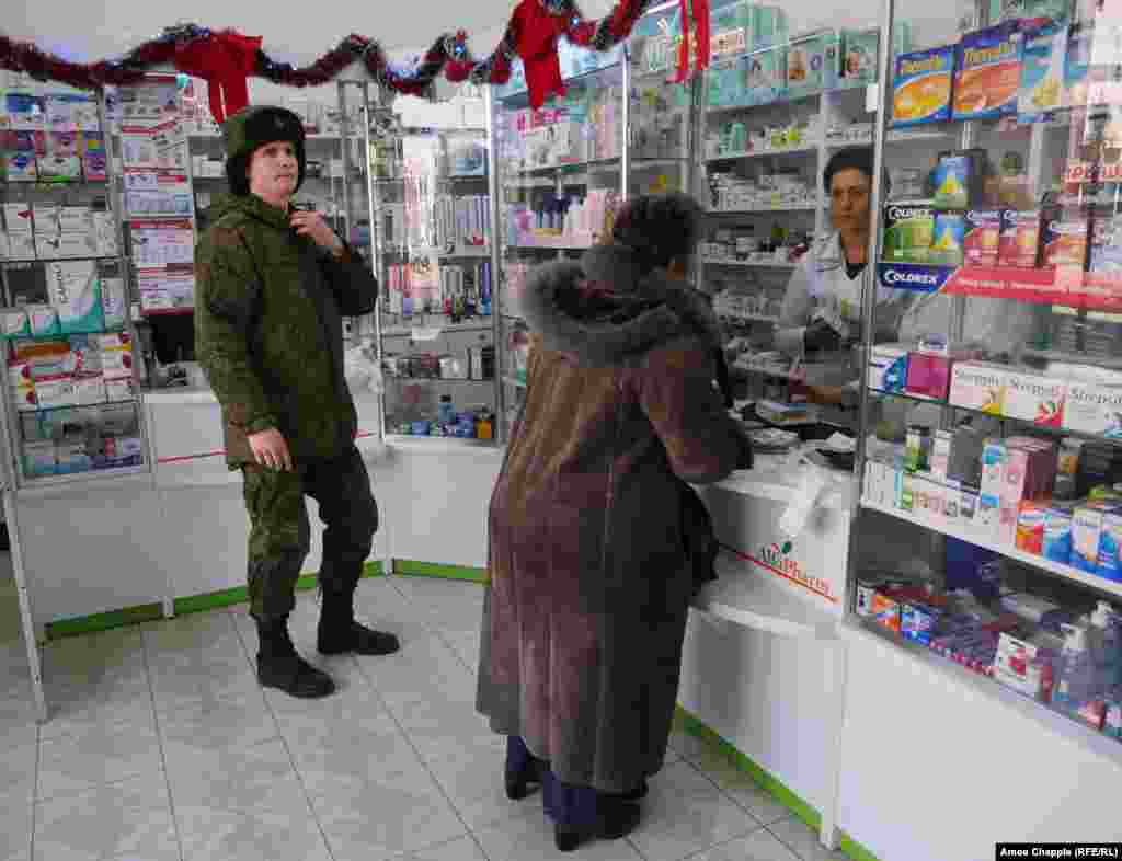 A young Russian soldier waits his turn inside a pharmacy in the center of Gyumri.