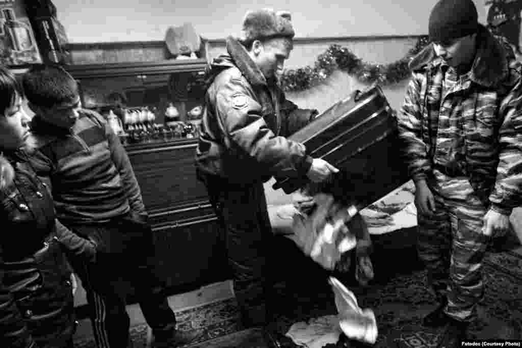 A Russian nationalist and a policeman search a basement where migrants live. St. Petersburg, 2012. Photo by Mikhail Domozhilov.