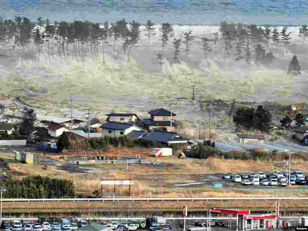 A massive tsunami engulfs a residential area after a powerful earthquake in Natori, Miyagi prefecture in northeastern Japan.Photo by Reuters
