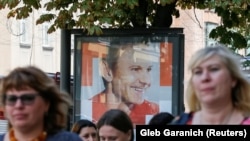 Киевляне на фоне билборда лидера "Голоса" Святослава Вакарчука.