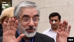 Former presidential candidate Mir-Hossein Mousavi waves to media as he leaves a press conference in Tehran, May 29, 2009