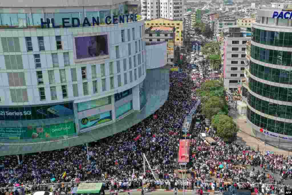 Această fotografie arată protestatari care participă la demonstrații în Yangon.&nbsp;(Photo by STR / AFP)