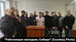 На суде в Сургуте - "честный гаишник" Сергей Иванов стоит в центре в синем пуховике