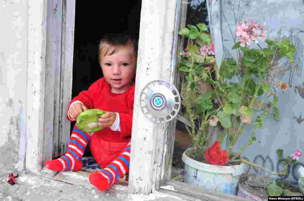 Малыш сидит на подоконнике, одно из сел Гегаркуникской области Армении