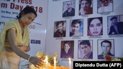 خبرنگاری در هند به احترام ۱۰ خبرنگاری که دهم اردیبهشت امسال در کابل کشته شدند شمع روشن می‌کند.