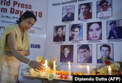 Indija: Indijska novinarka pali svijeće tokom bdijenja za deset afganistanskih novinara koji su ubijeni u napadima u Kabulu, april, 2018.