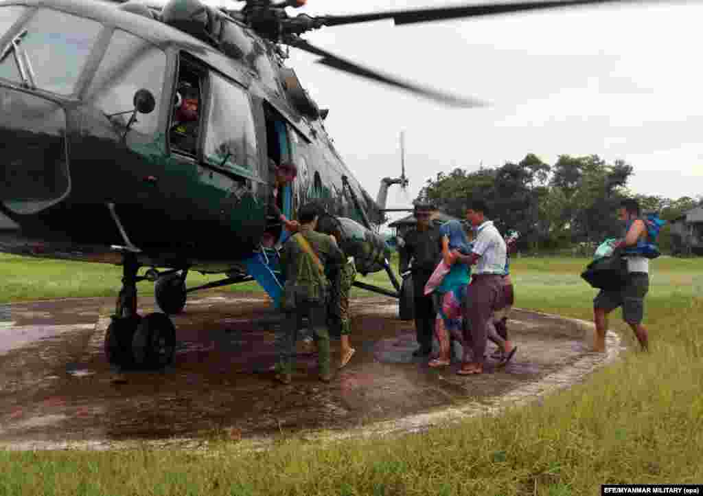 Burmese soldiers rescue people of the Daingnet ethnic group, part of the country's Buddhist majority, in Rakhine State, during an outbreak of fighting between militants and security forces.