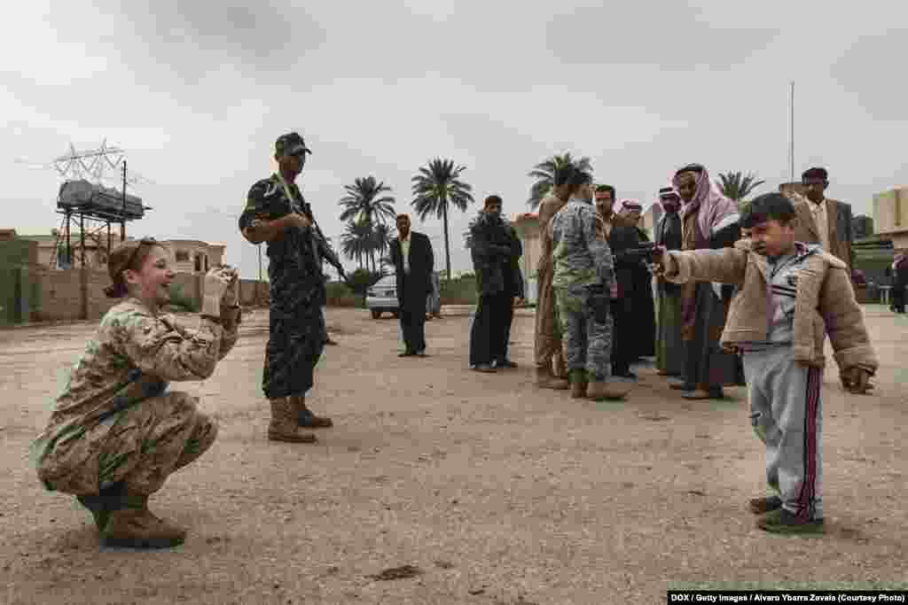 U.S. Army Major Megan McLung, 43, takes a photo of the son of one of the most important tribal families in Ramadi, a new ally of the U.S. army in Iraq. One hour after this picture was taken, Major McLung died in an ambush set up with an IED (improvised explosive device). November 2007