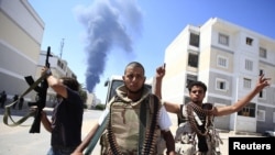 Rebel fighters react as they search for snipers while fighting to flush out Muammar Qaddafi's forces in the Abu Slim area in Tripoli.