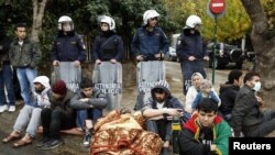 A group of Iranian refugees, some of them with their mouths sewn shut, protest outside the UN refugee agency office in Athens demanding asylum.