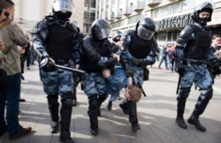 Riot police detain a participant of an unsanctioned rally urging fair elections in Moscow on August 3.