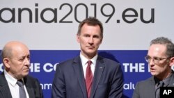 German Foreign Minister Heiko Maas, right, French Foreign Minister Jean-Yves Le Drian, left, and Jeremy Hunt United Kingdom's Secretary of State for Foreign and Commonwealth Affairs, stand during statements at a Gymnich meeting of EU foreign ministers in 