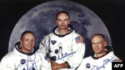 مایکل کالینز (وسط) در لباس فضانوردی