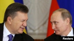 Колишній президент України Віктор Янукович, який втік до Росії, та президент РФ Володимир Путін після засідання російсько-української міждержавної комісії в Кремлі, Москва, 17 грудня 2013 року