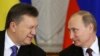 Then-Ukrainian President Viktor Yanukovych (left) gives a wink to Russian President Vladimir Putin at the Kremlin in Moscow in December 2013.