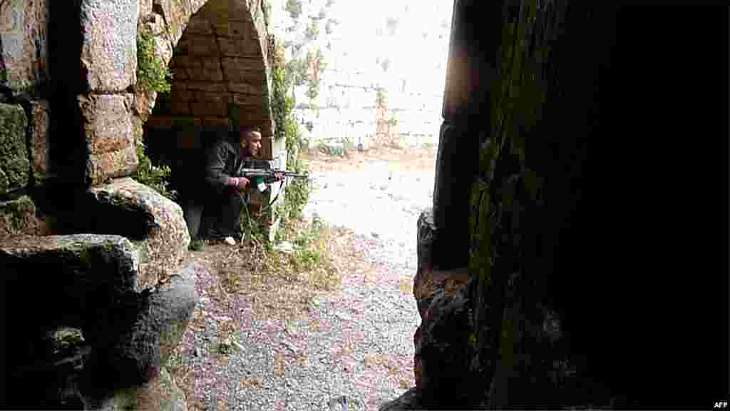 A rebel takes position at the Crac des Chevaliers Castle near the village of Azzara on the outskirts of the city of Homs on June 28, 2012.