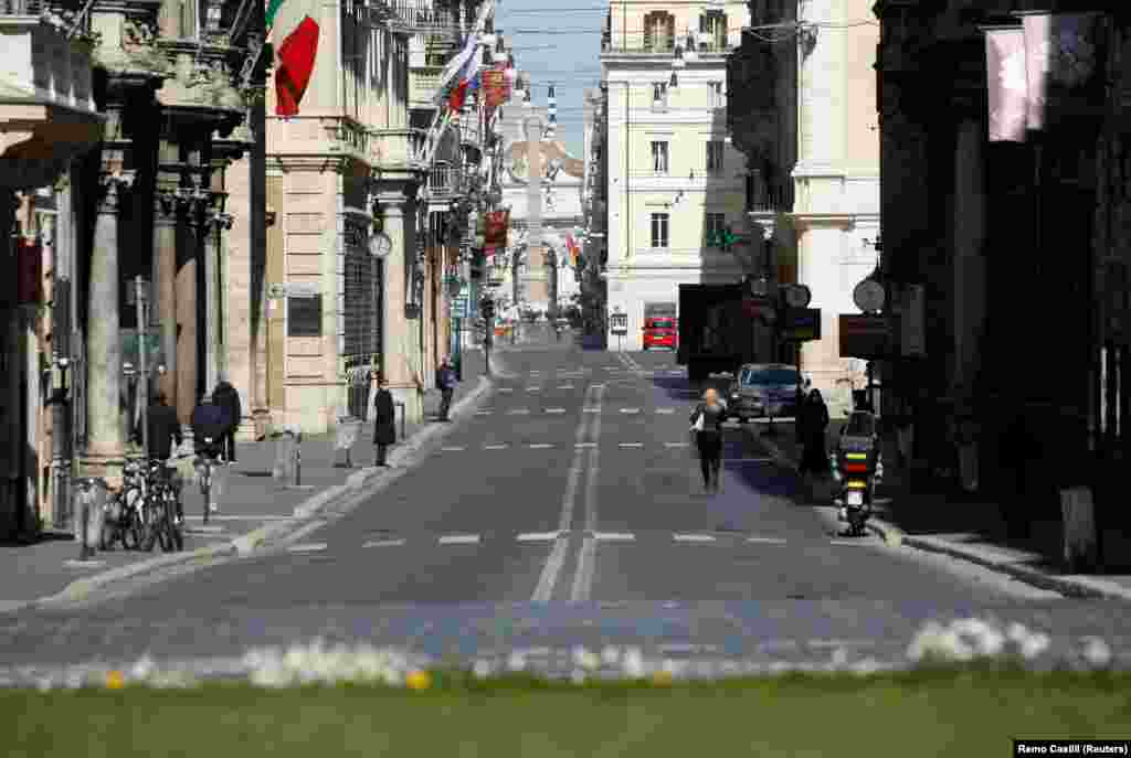 italy - People walk in an almost empty Via del Corso, as Italy tightens measures to try and contain the spread of coronavirus disease (COVID-19), in Rome, 23Mar2020