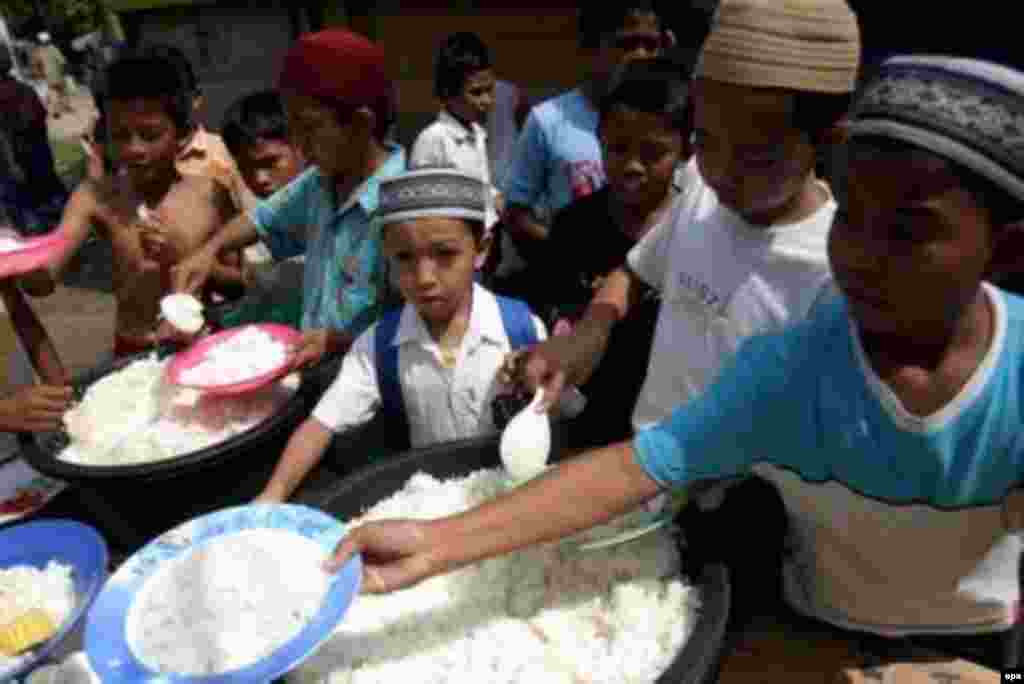 .بچه های بی خانمان اورفان اندونزی در صف غذا ، یک سال بعد از فاجعه سونامی