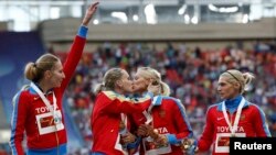 Russia's gold medal-winning team kiss and celebrate their women's 4x400-meter relay victory at the IAAF World Athletics Championships in Moscow on August 17.