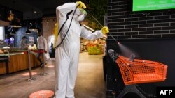 Kosovo - A worker disinfects a shopping cart in a supermarket in Pristina on April 17, 2020,