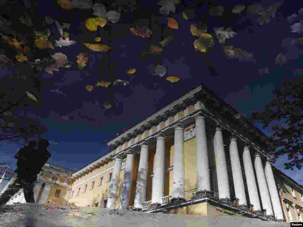 The silhouette of a pedestrian passing the main Admiralty building is reflected in a puddle in St. Petersburg, Russia, on October 12. (Photo by Alexander Demianchuk for Reuters)