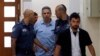 File photo:ISRAEL -- Gonen Segev, a former Israeli cabinet minister indicted on suspicion of spying for Iran, is escorted by prison guards as he arrives to court in Jerusalem on July 5, 2018.