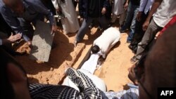 Friends and relatives bury the body of Abdelbaset al-Megrahi during his funeral in Tripoli.