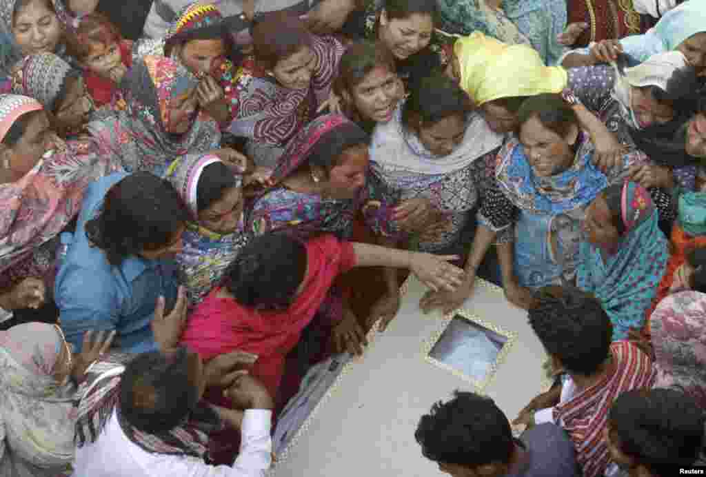 Family members mourn as they gather near the body of a relative, who was killed in a blast outside a public park in Lahore on March 27. (Reuters/Mohsin Raza)