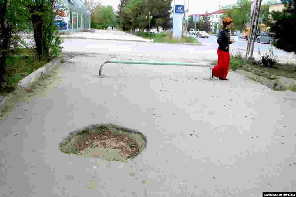 Turkmenistan. 10. street road fails. dent on the pedestarian road and a woman