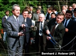 Ministrul maghiar de externe Gyula Horn și omologul său austriac Alois Mock taie gardul de sîrmă ghimpată a fostei Cortine de Fier care marca granița dintre ESt și Vest, Sopron, Ungaria, 27 iunie 1989