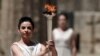 Actress Ino Menegaki, playing the role of high priestess, holds up the Olympic flame during a dress rehearsal for the torch-lighting ceremony of the London 2012 Olympic Games at the site of ancient Olympia on May 9.