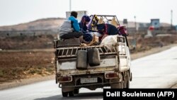 Syrian Kurdish and Arab families are pictured fleeing the border area between Syria and Turkey last week. 