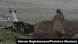 An ethnic Armenian soldier in Nagorno-Karabakh's forces stands near an artillery unit in the town of Martakert, where clashes with Azeri forces are taking place, on April 3.