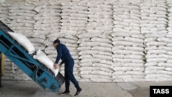 A worker stacking sacks of sugar in a distribution warehouse at the Karachay-Cherkessia Sugar Factory in Russia