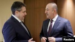 German Foreign Minister Sigmar Gabriel (left) meets Turkish Foreign Minister Mevlut Cavusoglu at the Adlon hotel in Berlin on March 8.