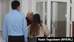 Секретарь судебной коллегии уводит адвоката Серика Сулейменова (в центре) в какое-то отдельное служебное помещение, где состоится заседание судебной коллегии по рассмотрению апелляционных жалоб по делу Константина Сыроежкина. Алматы, 28 ноября 2019 года. 