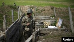 Nagorno-Karabakh -- An ethnic Armenian soldier stands guard in a trench at artillery positions near the Nagorno-Karabakh's town of Martuni, April 7, 2016